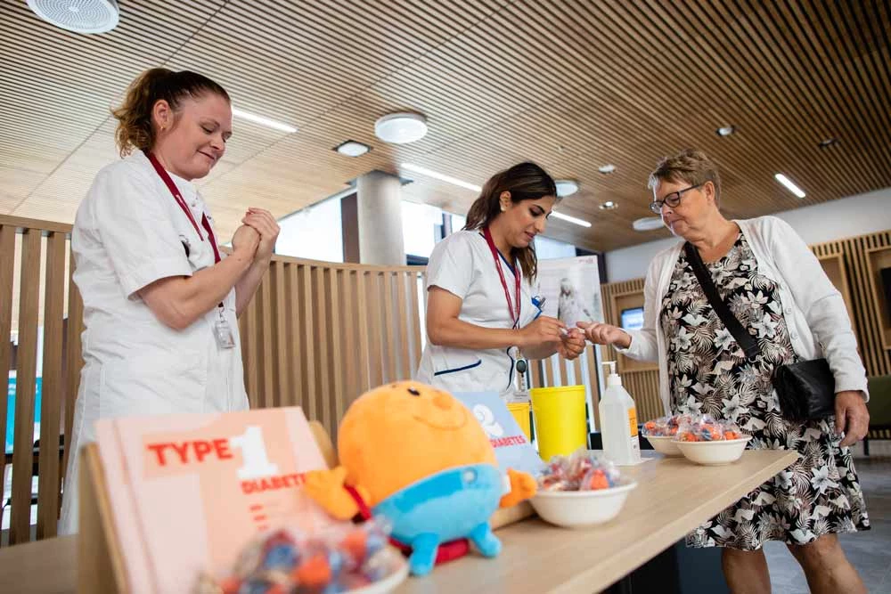 Billede af to sygeplejersker, der vejleder besøgende