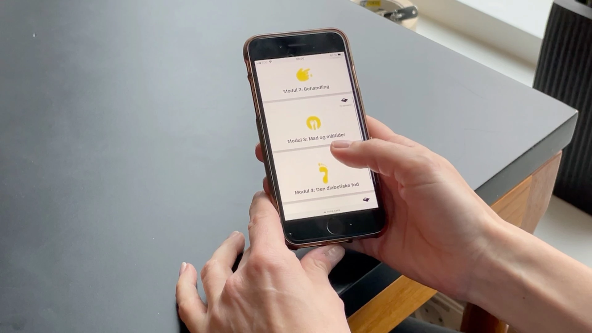 Person sidder med telefon med appen DiabetesGuide