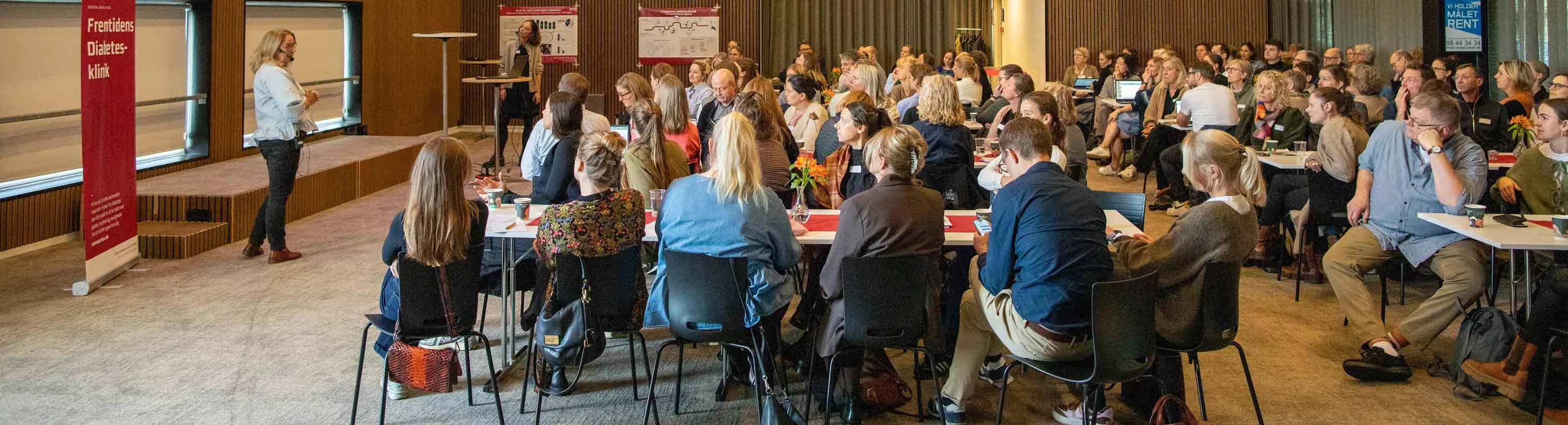 Billede af mennesker, der lytter til oplæg