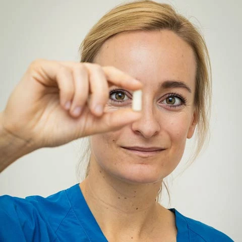 Portræt af Katrine Høyer med en pille med tarmbakterier