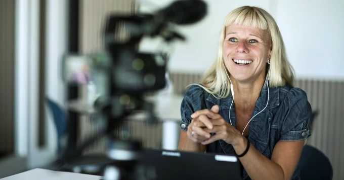 Billede af kvinde med høretelefoner i ørerne 